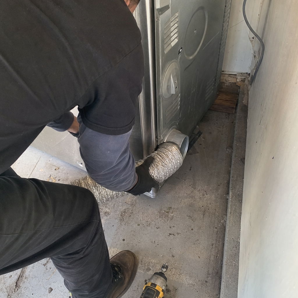 Professional technician performing dryer vent cleaning and exhaust hose connection